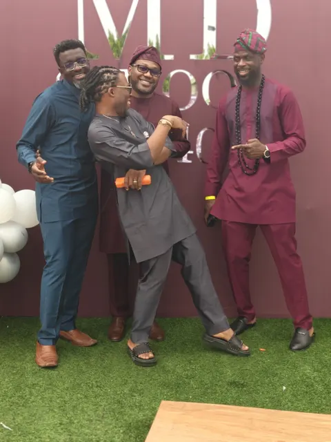 Guests in burgundy and grey celebrating in front of the M.D backdrop